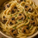 Bowl of creamy mushroom pasta garnished with parsley and Parmesan.